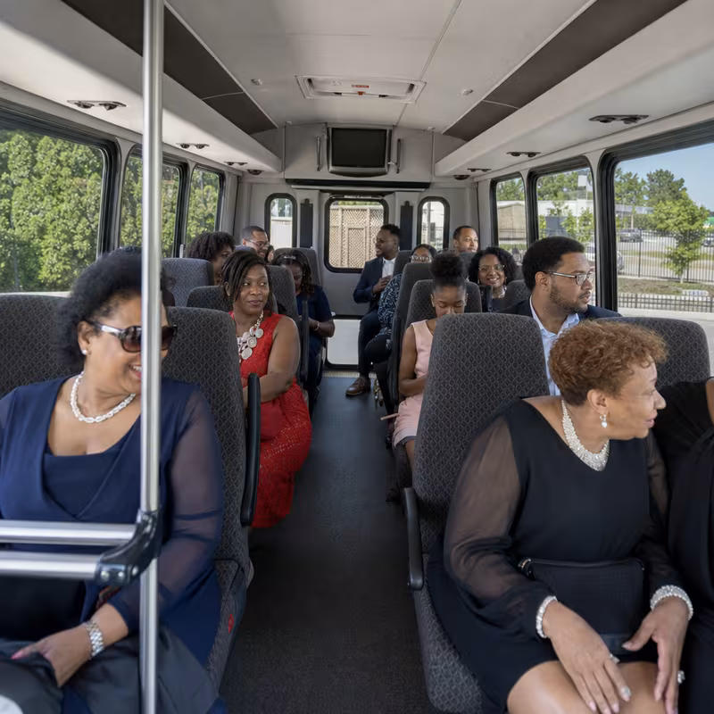 Group boarding a white charter bus for Private Event Transportation transportation in Bellevue