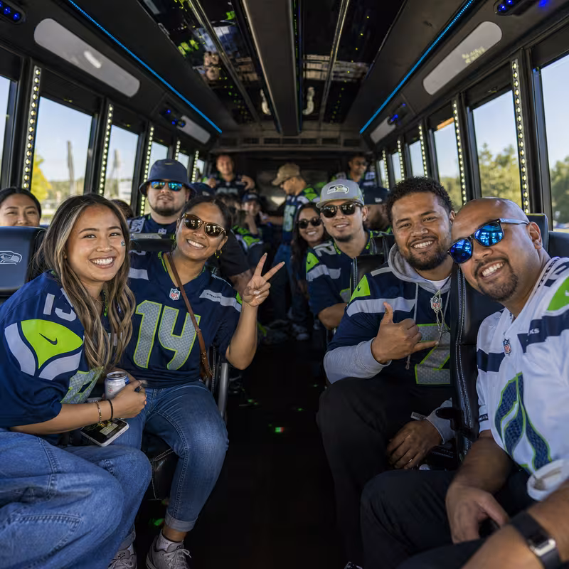 Group boarding a white charter bus for Sporting Event Transportation transportation in Bellevue